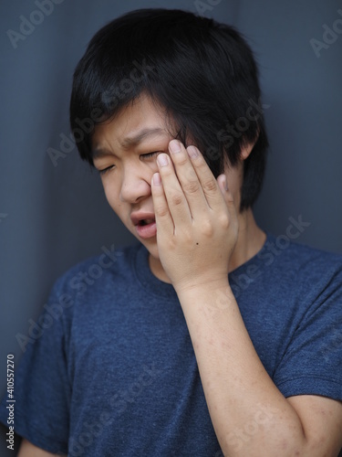 Funny portrait of 11 years old asian boy with dark blue t shirt	