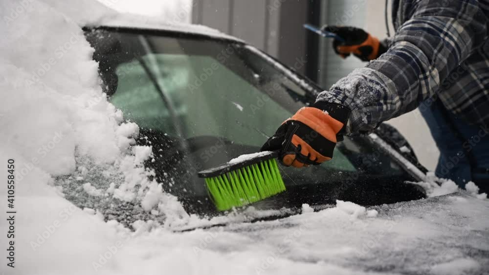 Men Removing Snow From His Vehicle and Deicing Windshield. Men Removing Snow From His Vehicle and Deicing Windshield.