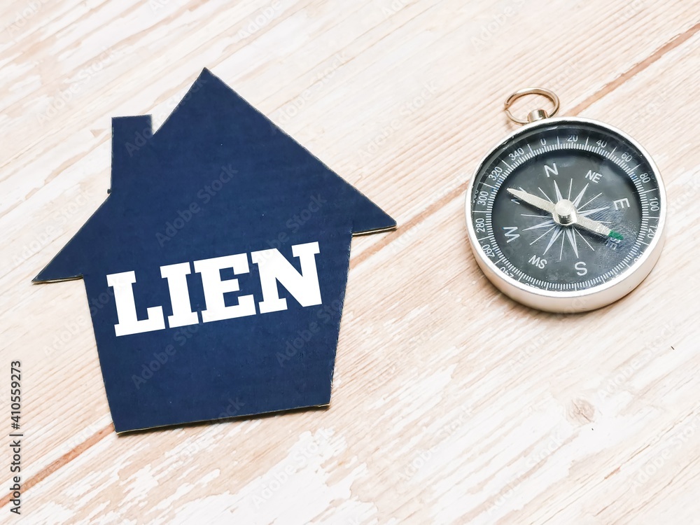 Top view text LIEN on cupboard house with compass. Property concept. Top view text LIEN on cupboard house with compass. Property concept.