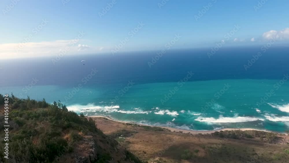 Aerial shot from drone films Parachutes flying over beach in Oahu, hawaii Aerial shot from drone films Parachutes flying over beach in Oahu, hawaii