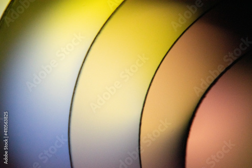 Background macro image pattern made of folded curved sheets of paper with multi color light illuminate 