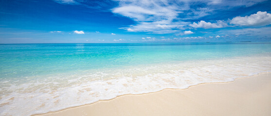 Closeup of sand on beach and blue summer sky. Panoramic beach landscape. Empty tropical beach and seascape. Blue sky, soft sand, calmness, tranquil relaxing sunlight, summer mood. Travel vacation