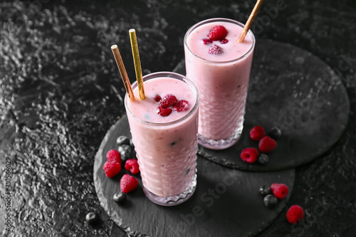 Fototapeta Naklejka Na Ścianę i Meble -  Glasses of delicious smoothie with blueberry and raspberry on dark background
