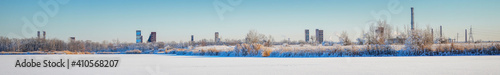 An abandoned old chemical plant on the bank of a frozen winter river covered with snow © pro2audio