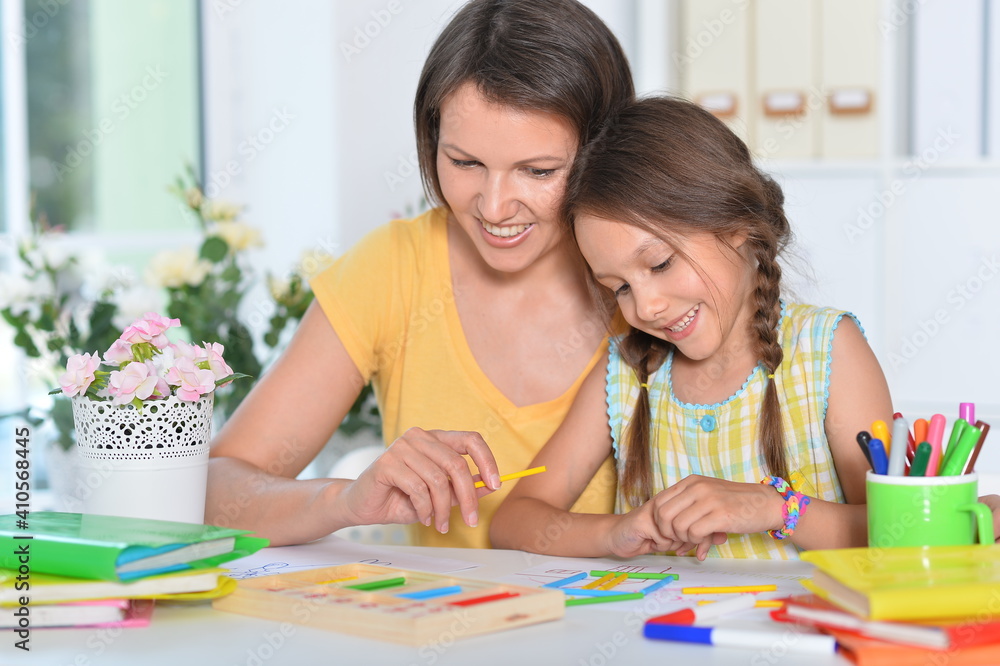 Mother teaching her daughter studying at home Mother teaching her daughter studying at home
