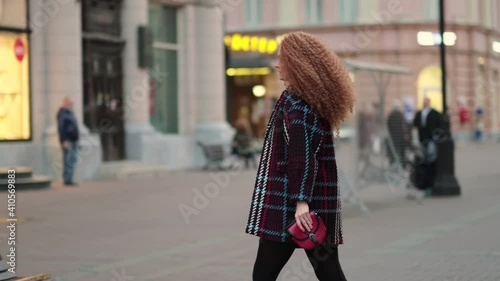 Beautiful young stylish woman walking in the city streets. alone in a big city. loneliness concept photo