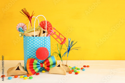 Purim celebration concept (jewish carnival holiday) over yellow background
