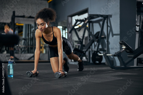 Young serious brunette woman doing physical training