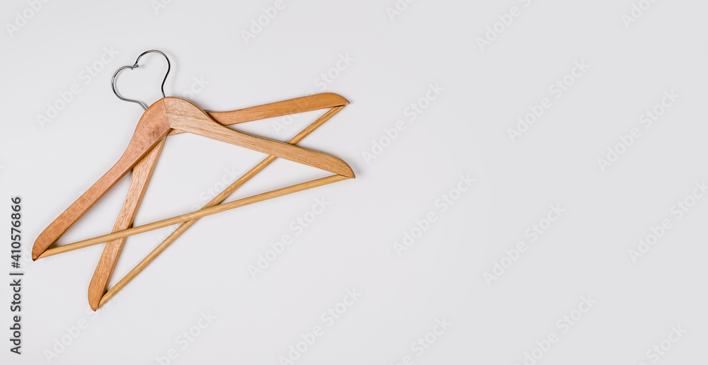 Clothes hangers made of wood on a light background. Hangers made of environmentally friendly material. Space for text Clothes hangers made of wood on a light background. Hangers made of environmentally friendly material. Space for text