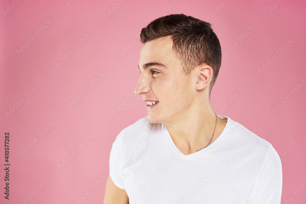 A man in a white t-shirt gestures with his hands emotions pink background studio cropped view A man in a white t-shirt gestures with his hands emotions pink background studio cropped view