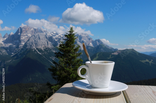 Primo piano di una tazzina da caffé con dietro una bellissima vista sulle montagne dal rifugio 5 laghi in Trentino, viaggi e paesaggi in Italia