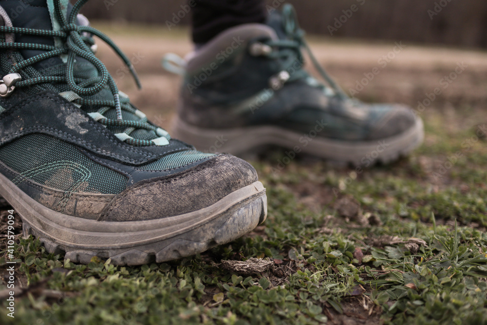 Women's trekking dirty boots in the grass and mud Women's trekking dirty boots in the grass and mud