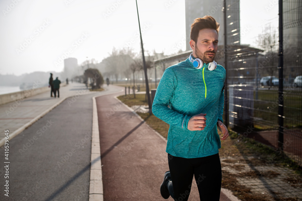 Obraz premium Young fitness man running in urban area
