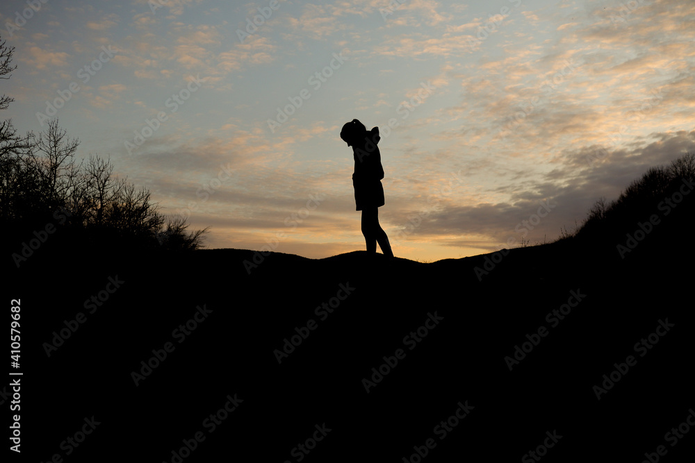 Girl silhouette with sunset sky background
