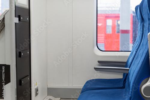 Train carriage interior with soft blue seats.
