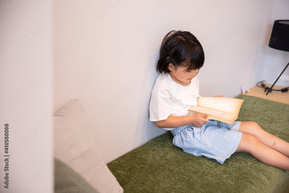かわいい女の子がひとりで家で絵本を読んでいる home girl かわいい女の子がひとりで家で絵本を読んでいる home girl