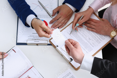 Group of people discuss plan at workplace closeup top view. Training course, mediation offer, university practice homework, school or college exercise, secretary job, desk talk, pad, arm concept