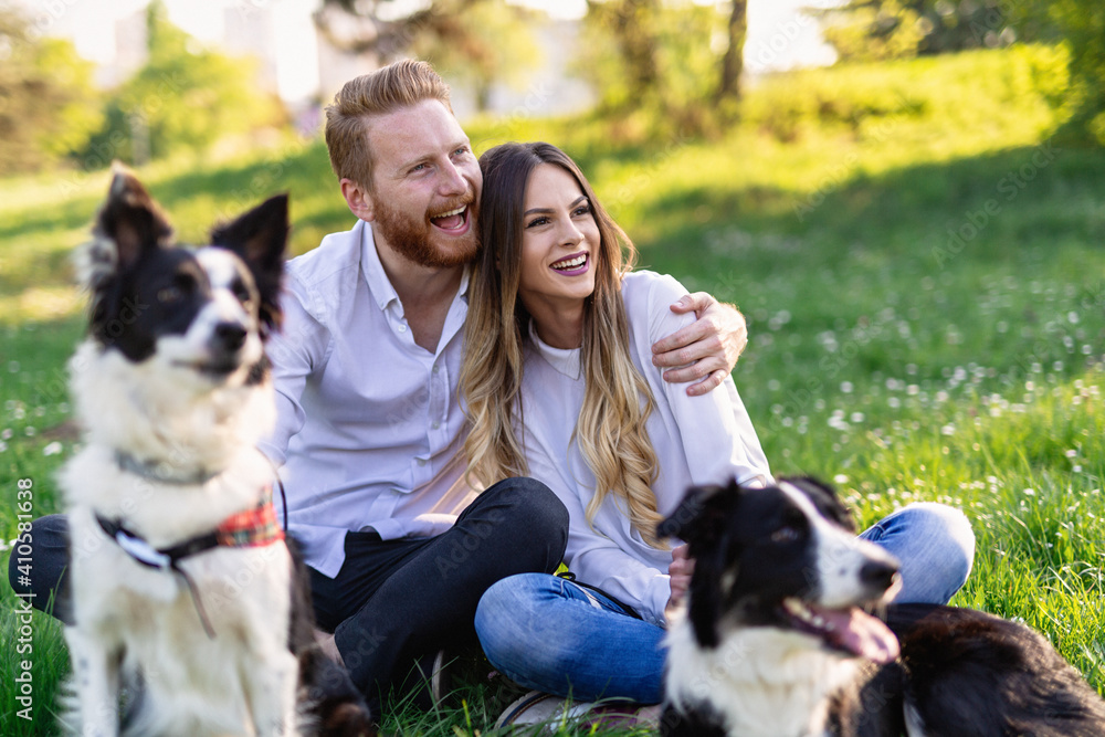 Happy couple playing with dog in the park outdoor Happy couple playing with dog in the park outdoor
