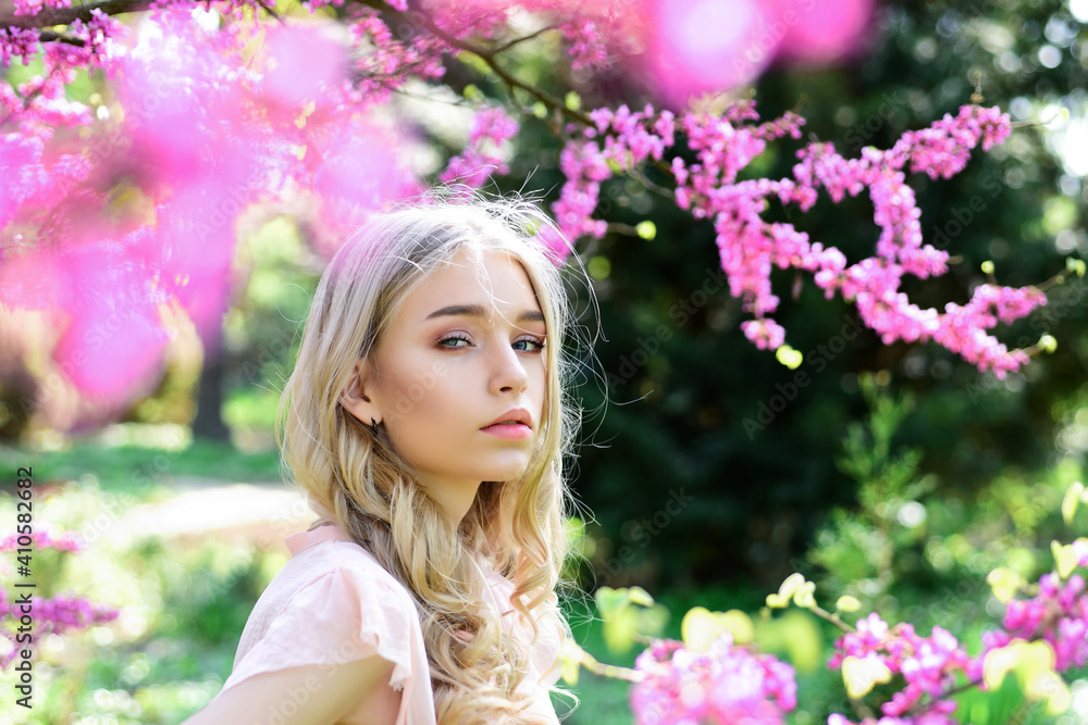 Spring bloom concept. Beautiful female face with perfect skin. Girl on dreamy face, tender blonde near violet flowers of judas tree, nature background. Beautiful Young Spring Woman. Spring bloom concept. Beautiful female face with perfect skin. Girl on dreamy face, tender blonde near violet flowers of judas tree, nature background. Beautiful Young Spring Woman.