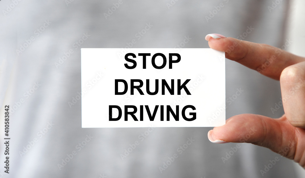 The girl holds a card with the text STOP DRUNK DRIVING. The girl holds a card with the text STOP DRUNK DRIVING.