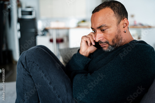 Depressed mixed race man talking on the phone