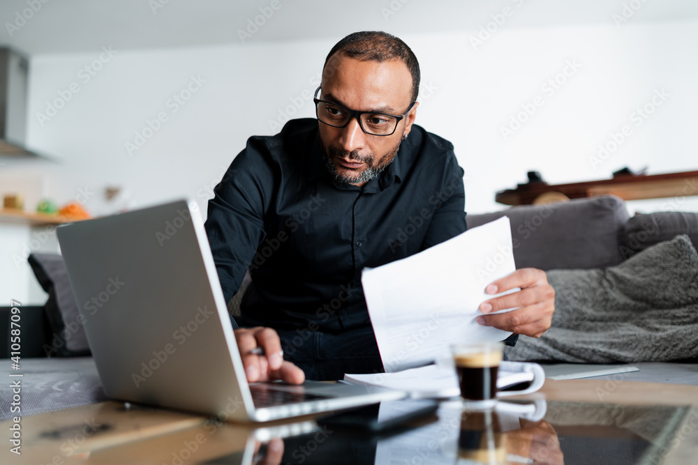 Mixed race man accounting at home Mixed race man accounting at home