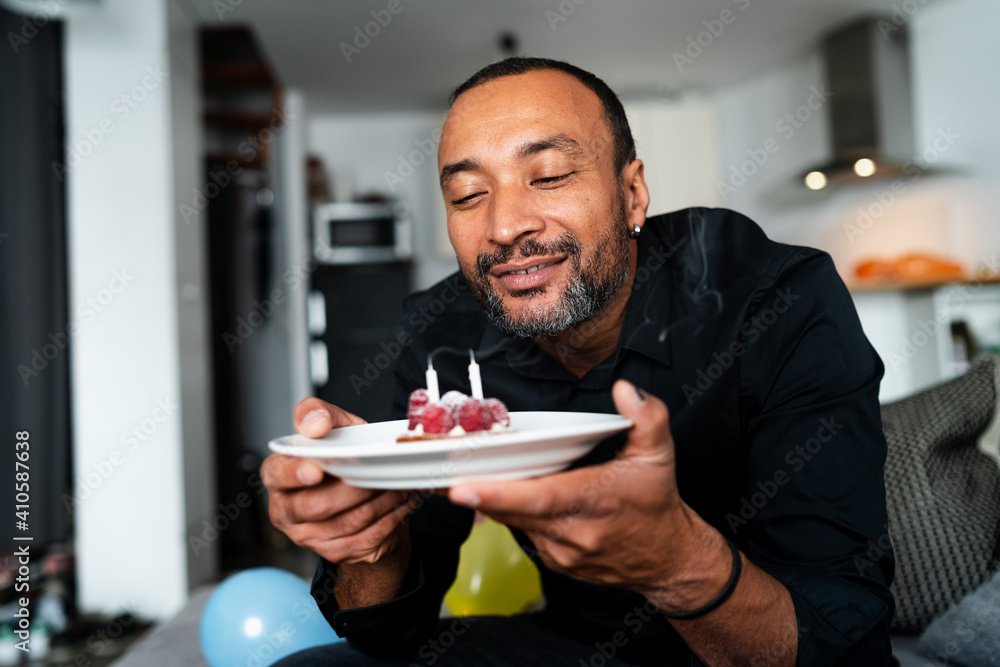Happy middle aged man celebrating his birthday at home