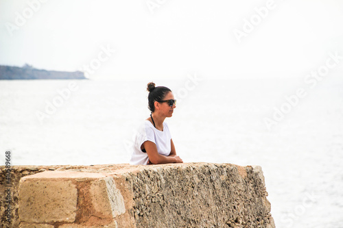 latin girl in a gazebo by the sea and with sunglasses 