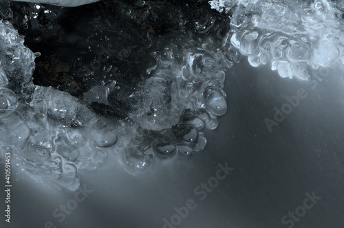 clean ice shapes with freezing river stream underneath