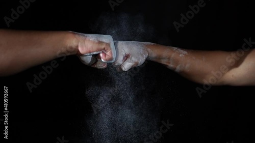 Two men fists attack with explosion powder on black background in slow motion. Sport concept for opening.
