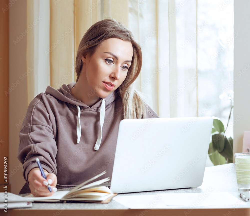 Young woman using laptop, communicates on internet with customer at home Young woman using laptop, communicates on internet with customer at home
