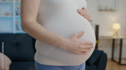 Young woman stroking belly, expecting baby, fetal development stages, trimester