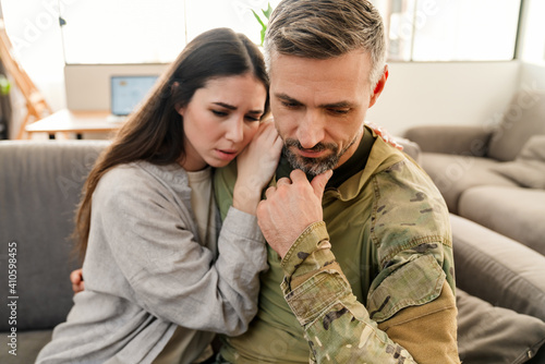 Sad young military soldier saying goodbye to sad wife