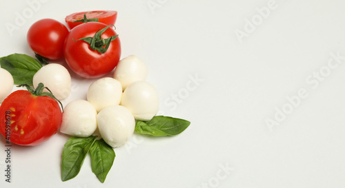 Mozzarella cheese, tomato and basil on white background, space for text