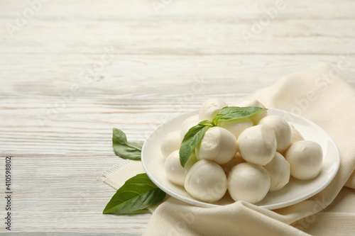 Kitchen towel with plate with mozzarella and basil on wooden background