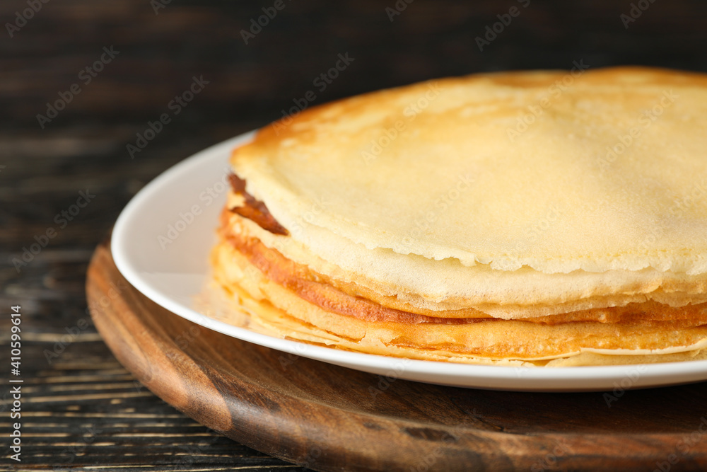 Board with thin pancakes on wooden background Board with thin pancakes on wooden background