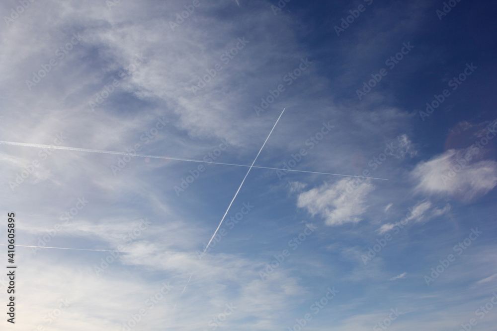 Airplane flies leaving contrail trace on blue sky. Cross in the sky Airplane flies leaving contrail trace on blue sky. Cross in the sky