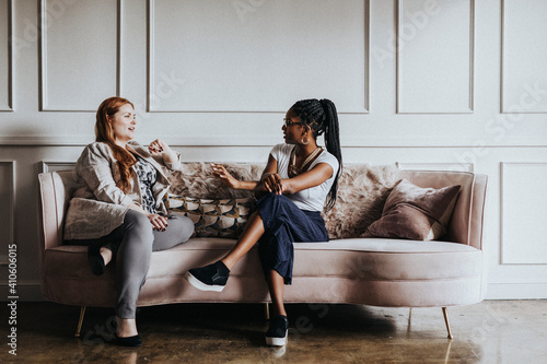 Happy friends enjoying a conversation together on the couch