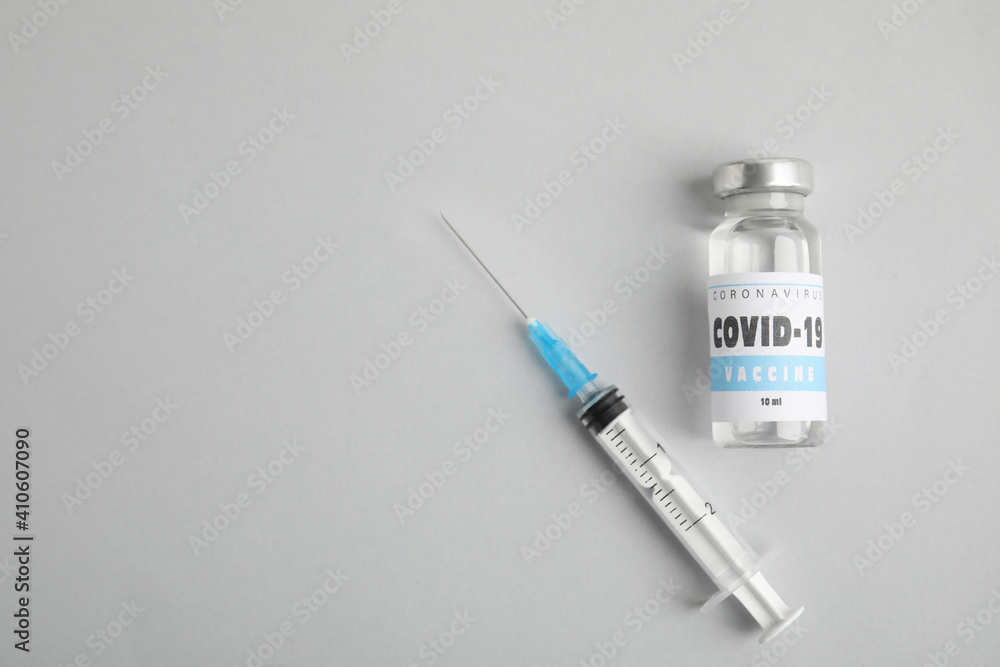 Vial with coronavirus vaccine and syringe on light background, flat lay. Space for text Vial with coronavirus vaccine and syringe on light background, flat lay. Space for text