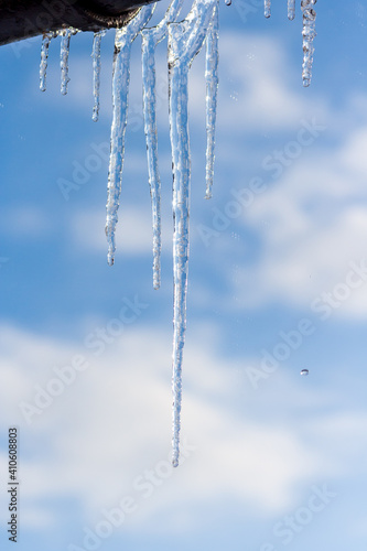 Icicles hanging from roof of house. Winter concept. Closeup danger icicles. Frozen climate pattern. Frost winter