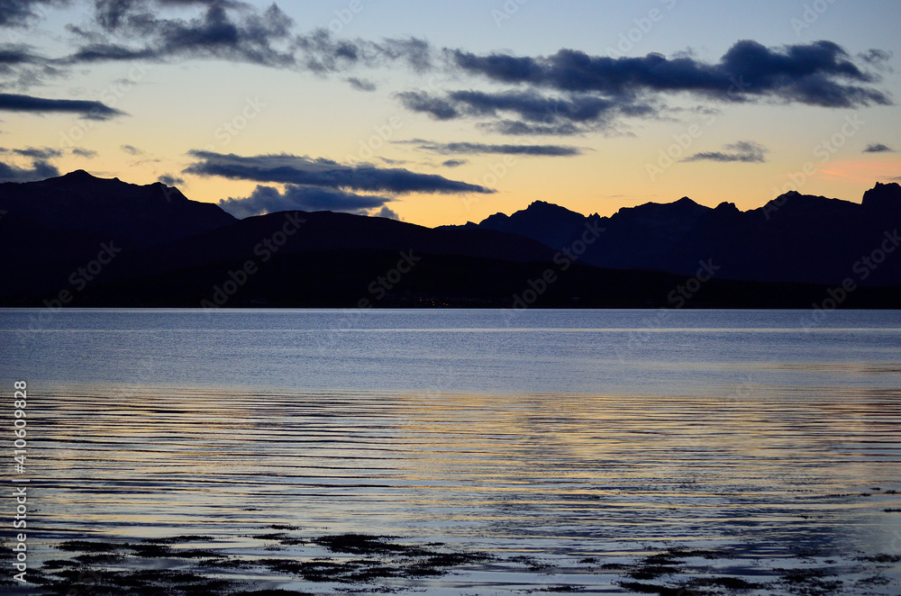 beautiful colours behind mountain range and in fjord as the sun is going down