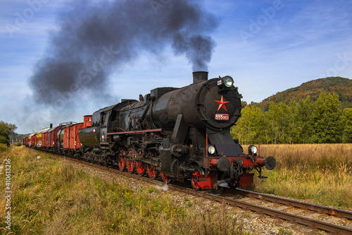 historic retro steam locomotive with freight train