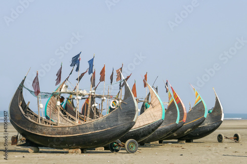 Colorful traditional wooden fishing boats known as moon boats resting dry on Inani beach, Cox's Bazar, Bangladesh photo