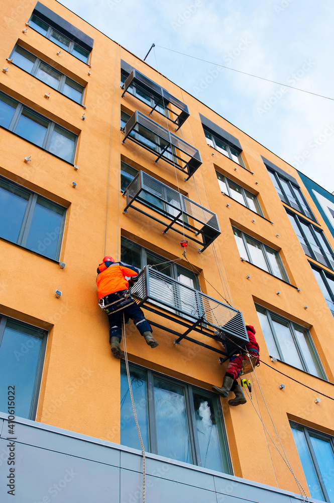 workers install niches for air conditioners on the house under construction workers install niches for air conditioners on the house under construction