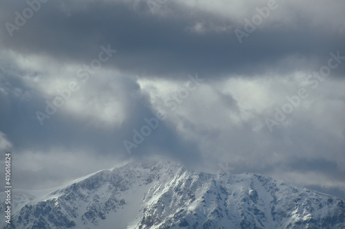 Schneebedeckter Berg mit dramatischen Wolken