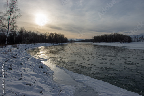 Winter sunset on the banks of the forest river