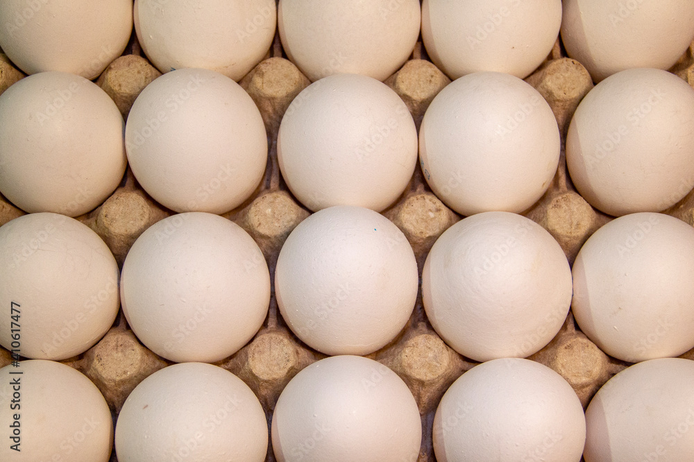 Full package of chicken eggs. Large white chicken eggs in cardboard packaging Full package of chicken eggs. Large white chicken eggs in cardboard packaging