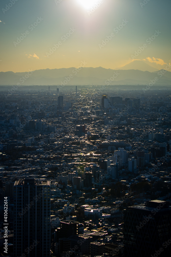 夕方の東京の街並みと太陽