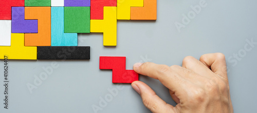 hand connecting geometric shape block with colorful wood puzzle pieces. logical thinking, business logic, Conundrum, decision, solutions, rational, mission, success, goals and strategy concepts photo