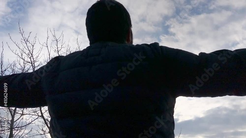 Reverent young man looks to sky at Mont Saint-Michel on France coast